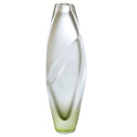 JACQUELINE TERPINS  Floreira em cristal transparente de Murano, de formato alongado irregular, ornamentado ao centro por faixa transversal em leve relevo Base realçada em tonalidade esverdeada. Assinada. 34 x 10 cm. 2 pequenos bicados.