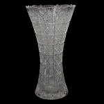 Vaso floreiro em cristal destacado de formato alongado, base estreita que se alarga levemente no topo e acabamento texturizado em relevo. 36 x 18 cm.