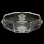 ROSENTHAL. Design da MAISON VERSACE. Modelo Medusa Lumiere - Fruteira de pé baixo em cristal, de formato octogonal. Bojo ornamentado por quatro máscaras acetinadas aplicadas em alto relevo, borda lapidada em biseauté e base de mesmo estilo. Peça assinada. 4 x 13 x 13 cm.