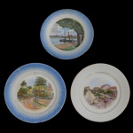 Conjunto de 3 pratos em porcelana policromada europeia representando O centro apresenta uma cena iconográfica policromada com paisagens ou pontos turísticos históricos do Brasil daquela época, como portos, praças e avenidas de cidades como Rio de Janeiro, São Paulo e Recife., sendo,A) Borda azul, centralizando paisagem com rio e legenda .... Marca da manufatura belga Boch Frères La Louvière. 19 cm. B) Borda azul, apresentando rua de cidade e legenda Magdalena - Pernambuco. Marca da manufatura holandesa Société Céramique Maestricht. 18 cm. C) Borda branca, decorado com a Rua Municipal no Rio de Janeiro.  Marca da manufatura belga Petrus Regout Maastricht Made in Holland. 20 cm. Um deles com bicado. 