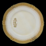 VISCONDE DE GUAÍ - Prato de porcelana de Vierzon, pertencente ao Serviço do Visconde de Guaí (Joaquim Elísio Pereira Marinho), da manufatura de Jules Etienne, Paris. Pasta dura. Borda apresentando friso dourado com arabescos em relevo, delimitando renda igualmente dourada. Disposta assimetricamente, a inicial G envolvida por coroa de conde, em dourado. Final do séc. XIX / XX. 20 cm. RESTAURADO. Peça do mesmo serviço reproduzida à pág. 260 no Livro Louça da Aristocracia do Brasil, por Jenny Dreyfus.