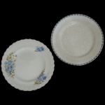 J, & G MEAKIN e JOHNSON BROTHERS, England - Lote constando de 2 pratos de louça inglesa, sendo: A) Apresenta fundo liso com uma faixa circular detalhada com padrões geométricos repetitivos em tons escuros. B) Apresenta fundo liso com bordas onduladas e decorações florais assimétricas em tons de azul e amarelo.  23 cm.