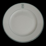 CARL ROBERT TIELSCH (18151882) - Prato raso em porcelana alemã. Superficie de fundo neutro com friso verde e monograma entrelaçado. 24 cm. A empresa Carl Tielsch foi fundada em 1845 e tornou-se uma das mais importantes fabricantes de porcelana da região, competindo em qualidade com a KPM Berlin