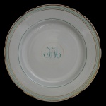 Prato em porcelana espanhola sevilhana, decorado em verde e ouro, com borda ondulada e realçada por filetes. Apresenta ao centro monograma I de la H. Sob a base, marca da famosa manufatura La Caruja de Sevilla - Pickman y Cia - Medalla Exposición Londres 1862  Sevilla. 25 cm.