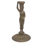 Castiçal de petit bronze estilo Art Nouveau representando uma figura feminina, caracterizado por formas elegantes. 30 x 17 cm.