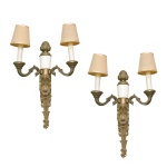 Elegante par de arandelas antigas no estilo Luís XVI em bronze fundido com pátina envelhecida e detalhes centrais que simulam porcelana. Hastes decoradas com folhas de acanto, guirlandas neoclássicas e ponteiras ornamentadas na base inferior. Cúpulas de tecido em tom bege, perfeitas para suavizar a luz direta. 45 x 35 cm.