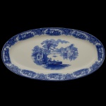 W.H. GRINDLEY. Inglaterra - Travessa em louça inglesa em formato oval com decoração estilo Flow Blue " ou azul borrão. Apresenta paisagens orientais com castelos e pagodes.