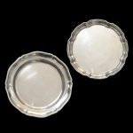 Lote constando de 2 travessas em metal prateado sendo: A)  Wolff, bordas onduladas filetadas com centro liso. 38 cm) B) Shefield Plate, bordas onduladas, filetadas com um centro liso. 36 cm.