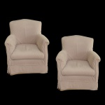 Par de poltronas estofada, de modelo clássico. Possui braços arredondados e encosto fixo. Estafado em tecido de cor neutra. 88 x 65 x 56 cm.