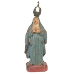 Imagem em madeira policromada de N. Sra da Anunciação. Apresenta-se tradicionalmente com longa túnica e manto azul que lhe cobre a cabeça. As mão cruzadas sobre o peito em sinal de aceitação de ser mãe de Jesus. Base chanfrada. Acompanha coroa em metal. Séc. XIX. Marcas do tempo.