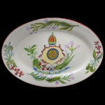 Travessa em louça oval pertencente ao Serviço da Independência. Adquirido da coleção dr. Armando de Arruda Camargo. Número 1101. Decoração com Brasão de Armas. Bicado na borda por fora. 37 x 27 cm.