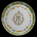 Prato em porcelana comemorativo possivelmente pelo aniversário da coroação de D. Pedro II. Marca da manufatura B. Wallerstein&Co.  Rio de Janeiro. Pertenceu a coleção do Dr. Julio Pinotti. 26 cm.