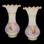 Par de vasos em opalina de formato balaústre, ornamentados à meia altura por larga faixa lilás, com filetes em ouro. Bojos abaulados, encimados por gargalos revirados e com babados. Bases circulares, retraídas e aneladas. 25 x 14 cm.
