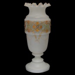 Vaso longilíneo em opalina leitosa com larga faixa com detalhes em ouro. Possui uma borda ondulada ("babado"), uma base circular e detalhes em ouro pintados à mão sobre o vidro. 31 x 12 cm.