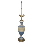 Luminária de mesa em cerâmica de cor azul com larga faixa em branco. Corpo em gomos e design neoclássico com figuras de querubins. Haste longa em metal dourado e base em bronze recortada. 100 cm )MT). .18 x 18 cm (base)