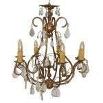 Lustre para 6 velas, no formato de gaiola piriforme, com estrutura tubular dourada. Globo inferior, sustentando braços recurvos, ornados por placas em cristal lapidado e rematados por velas com lâmpadas. Hastes superiores em S, reunidas ao topo por esfera encimada por colunata e pequeno prato bordado por adornos facetados. 77 x 60 cm. Falta uma lâmpada