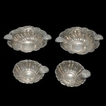 BRASIL> Prata 833 mls - Conjunto de 2 pares de cinzeiros em prata brasileira repuxada e cinzelada, de formato circular, moldados com gomos centralizando medalhões. Um par com 2 descansos em cada peça e bordas largas. Contraste do teor de 833 mls. 4 x 12 cm (maior). Peso 169 gramas. 3 x 8 cm. Peso 74 gramas.