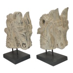 Par de esculturas de mesa de cabeça de cavalo da Galt International em madeira esculpidas em relevo com pátina clara. Apresentam formas esculpidas lembrando elementos arquitetônicos clássicos ou figuras mitológicas. 42 x 30 x 12 cm.