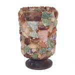 Luminária revestido artesanalmente com um mosaico de pedras naturais brutas e cristais coloridos. Esse estilo de luminária brutalista foi muito popular no design de interiores das décadas de 1950 a 1970. 18 x 11 x 10 cm. Quando aceso, a luz interna passa pelas frestas e pelas partes translúcidas das pedras brutas, criando uma iluminação difusa, texturizada e muito aconchegante.