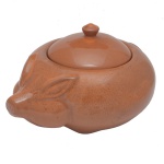 Caçarola para feijoada de cerâmica. Apresenta o corpo e a tampa modelados de maneira a imitar a anatomia de um porquinho. 17 x 30 x 25 cm.