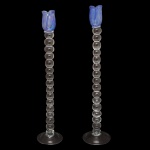 Par de castiçais de vidro artístico, apresentando um design de tulipa azul na parte superior e uma haste com esferas transparentes sobrepostas. 60 cm.