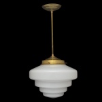 Luminária pendente Art Déco com cúpula de vidro em formato de "escada" ou "bolo de casamento" (wedding cake), caracterizada pelo acabamento em metal dourado e cúpula leitosa opaca. 22 x 30 cm a cúpula / 60 cm (MT).