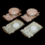 LIMOGES - Original conjunto em porcelana francesa, com 4 pequenas bandejas para xícaras e mignardises, de formato retangular. Apresentam decoração com estilizações a ouro, sendo 2 com fundos cor de rosa e 2 de cor azul. Apresentam um lado com centro escavado para suporte de xícaras e a outra parte lisa para petis fours. (Faltam as 2 xícaras azuis). Marcas da manufatura no verso. .4 x 10 cm (xícara) e 15 x 9 cm (pires).