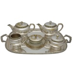 Conjunto para chá e café em metal espessurado a prata da manufatura nacional, Meridional, constando de 6 peças, sendo: grande bandeja retangular (60 x 43 cm), 1 bule p/café (15 x 24 cm), 1 bule p/ chá (12 x 24 cm), 1 leiteira (10 x 16 cm), 1 queijeira (6 x 17 cm) e 1 açucareiro (9 x 17 cm). Apresenta desgaste natural devido ao tempo e uso.