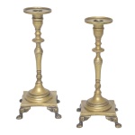Par de castiçais em metal dourado Coluna central detalhada e base elevada com quatro pés. 19 x 7 x 7 cm.