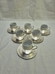 Jogo de 6 xícaras de café em porcelana com suporte e pires em prata 90, modelos diversos. Medidas: 5cm x 5,5cm de altura.