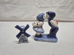 Lote de saleiro na forma de moinho e enfeite de casal holandês em porcelana azul e branca. Medindo o maior 11cm de altura.
