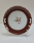 SCHMIDT- Prato decorativo em antiga porcelana ,  centro decorado com bouquet de flores, borda larga na cor ferrugem com dourados. Med. 26 cm diâmetro.