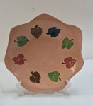 VINTAGE- Fruteira decorativa em cerâmica do Vale do Jequitinhonha, assinado Kica, formato circular, borda ondulada na cor  telha com folhas nos tons verde , marrom e azul. Med. 29 cm diâmetro.