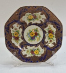VINTAGE- CARL TIELSH ALTWASSER - Prato decorativo em porcelana alemã ( período 1860-1930), formato octagonal, fundo azul cobalto com detalhes florais e rendilhados dourados. Med. 22 cm diâmetro.