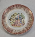 Prato decorativo em porcelana alemã, decorado ao centro com cena oriental e figuras, borda na cor rosa com rendilhados em dourado. Med. 24 cm diâmetro.