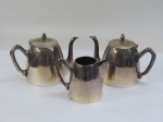 SPAM 90- Dois (02) bules para chá e uma cremeira em metal espessurado a prata. Med. bules 15 cm alt. Pequeno desgaste na prateação.