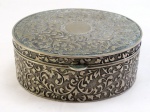 Uma (1) caixa porta joias oval confeccionado em metal espessurado a prata, ricamente cinzelada por elementos florais e fitomorfos em relevo, interior revestido em  veludo vermelho. Med. 7 x 16,5 x 14 cm.