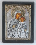 ARTE SACRA. Icone Russo , representando Virgem Maria e Menino sobre madeira em placa de metal prateado em alto relevo. Med. 15,5 x 12 cm.