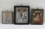Três (03) ícones russos revestidos com aplicações em metal prateado com detalhes em dourado, representando, Santo Raphael, São Nicolau e Irene de Lebos, e dois com Nossa Senhora e Menino Jesus. Medidas. 12 x 9,5 cm, 9,5 x 7,5 cm, 8 x 6,5 cm.
