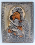 ARTE SACRA- Um ícone bizantino pintado sobre madeira representando Nossa Senhora com Menino Jesus, revestido em metal prateado cinzelado em relevo com aplicação em dourado. Med. 23 x 18 cm.