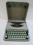 HERMES BABY - Máquina de escrever portátil da década de 1960, possui case original para transporte na cor verde. Med. 7,5 x 29 x 29 cm.