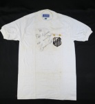 ANOS 60- Antiga Camisa retrô do Santos Futebol Clube autografada pelo Edson Arantes do Nascimento, o Rei Pelé com dedicatória " Ao Professor Marcos do Amigo Edson Pelé", camisa da Heringol com 100% algodão. Camisa com escudo dos santos e duas estrelas, com selo oficial em papel com a inscrição em preto. As duas estrelas representam o Bicampeonato Mundial de 1962/1963, em Maio de 1968 entrou nas camisas. Obs : Com antigas manchas de guardado..