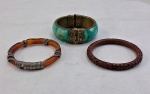 Três (03) pulseiras sendo: Uma em laca  chinesa ( 8,3 cm diâmetro), uma âmbar entrelaçada com metal prateado ( 8 cm diâmetro), Antiga pulseira/bracelete conhecida com escrava, em  metal decorada com turqueza com fecho ( 8 cm diâmetro).