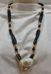 Colar de três voltas com pedras de lápis-lazuli, pérolas de água doce , contas douradas e grande pingente em concha de madrepérola. Med. aberto 65 cm comprimento.