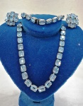 Elegante conjunto de gargantilha, pulseira e brinco confeccionado em metal prateado cravejado  com cristais azul-turquesa estilo Swarovski . Brinco de tarraxa. Med. gargantilha 38 cm aberto, pulseira 20 cm.
