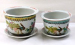 Dois (02) cachepots com prato em porcelana oriental, esmaltado em farta policromia com decoração floral, ave do paraiso e ideograma.  Bordas com gregas. Medidas: maior 1 x 15 cm, menor 9 x 13 cm.