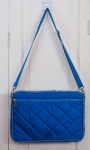 Bolsa da Uncle K, com acabamento acolchoado em Matelassê no tom azul, alças transversal regulável e fechamento em zíper. Med. 25 x 36 cm.