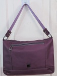 Bolsa de ombro da Uncle K, com acabamento acolchoado em nylon no tom lilás, dois bolsos externos, interior com uma bolsinha, forro interno. Med. sem alça 26 x 36 cm, com alça 48 cm.