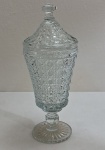 Grande compoteira executada em demi cristal, translúcido , ricamente moldado com padrão geométrico, contendo losangos e octogonos relevo, fuste facetado sobre base circular de fundo estrelado, padrão decorativo replicado na tampa. Medidas: Alt.: 32 cm x Diam.: 13,5 cm.