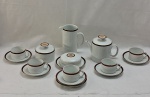 RENNER- SERIE MÉDAILLON-PÔRTO ALEGRE-Antigo jogo de chá em porcelana adornada com frisos grená com dourados, sendo ; um bule para chá ( 15 cm alt), uma leiteira ( 17 cm alt), açucareiro, mantegueira e cinco xícaras com pires.